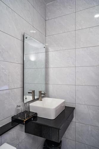 a white bathroom with a sink and a mirror at Boeung Prolet Guest House in Kampot
