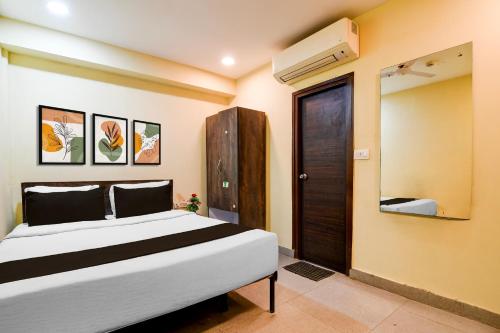 a bedroom with a large bed and a door at Hotel O Premium 12th Night in kolkata