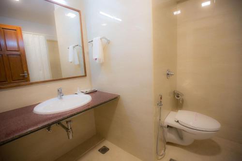 bagno con lavandino, servizi igienici e specchio di Hotel BMS a Mangalore