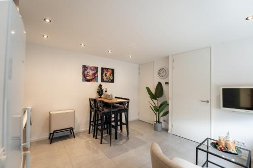a white living room with a table and chairs at In the heart of Tilburg in Tilburg