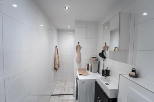 a white bathroom with two sinks and a shower at In the heart of Tilburg in Tilburg