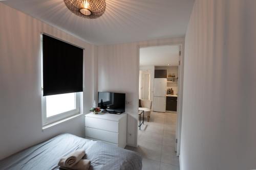 a bedroom with a bed and a television and a window at In the heart of Tilburg in Tilburg