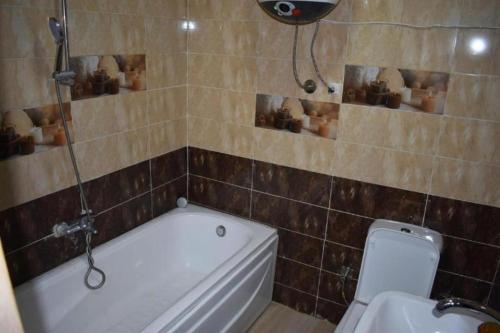 a bathroom with a tub and a toilet and a sink at Egypt Pyramids Hotel in Cairo