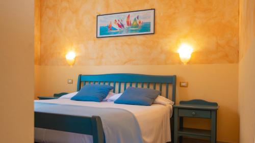 a bedroom with a blue bed with two blue pillows at Holiday Park Spiaggia e Mare in Porto Garibaldi