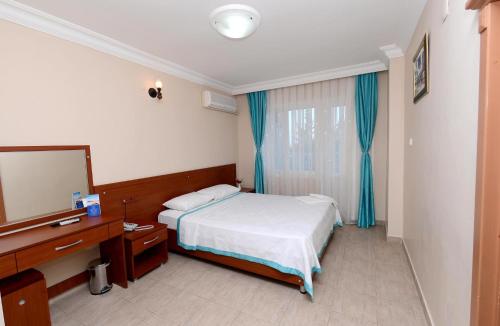 a hotel room with a bed and a mirror at Hotel Eylül in Erdemli
