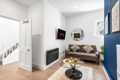 a living room with a couch and a table at Modern and spacious maisonette in Brighton & Hove