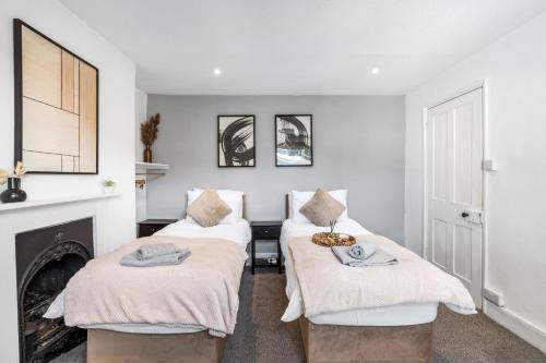 two beds in a room with a fireplace at Modern and spacious maisonette in Brighton & Hove