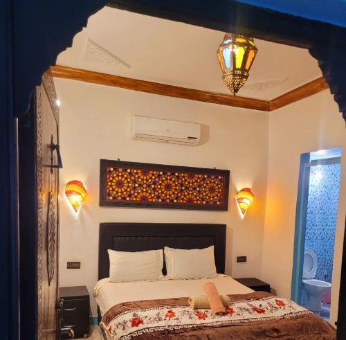 a bedroom with a bed in a room with lights at Dar Berrada-Ziat in Fez