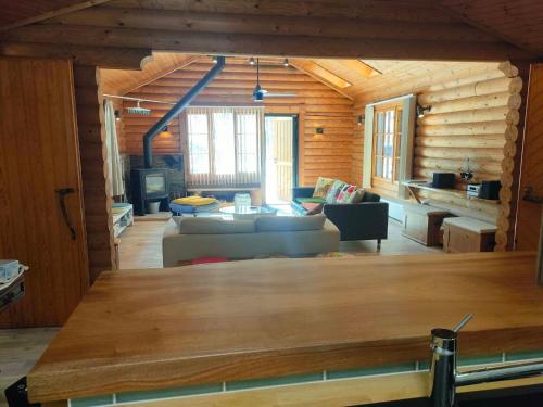 a living room in a log cabin with a couch at LOG-INN Hakuba in Hakuba