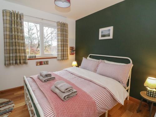a bedroom with a bed with two towels on it at Doire An Daimh in Acharacle