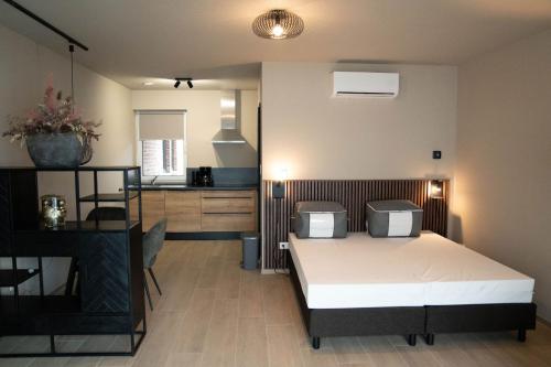 a bedroom with a bed and a kitchen at Camping Natuurlijk Limburg - Studio 1 in Voeren