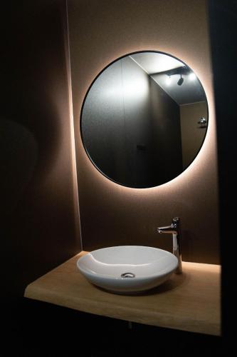 a bathroom sink with a large mirror on the wall at Camping Natuurlijk Limburg - Studio 1 in Voeren