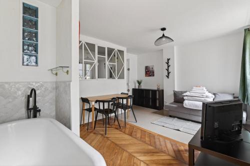 a bedroom and living room with a bed and a table at Premium 1BR flat with direct access to the RER B in Gentilly