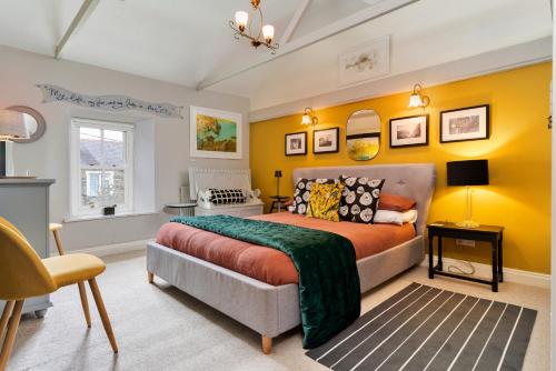 a bedroom with a bed and a yellow wall at Finest Retreats - Wallis Cottage in Fishguard