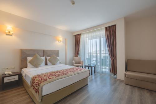 a hotel room with a bed and a chair at The Gap Hotel Kuşadası in Kuşadası