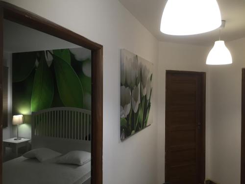 a bedroom with a mirror and a bed with flowers at Apartament U Sternika in Międzyzdroje