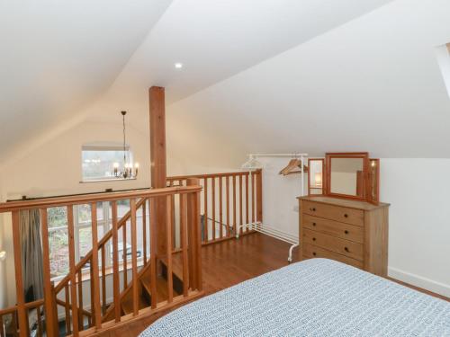 a bedroom with a bed and a wooden staircase at Horse Gin in Lydney