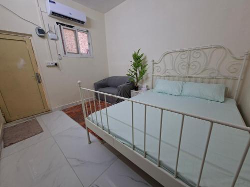 a bedroom with a bed and a chair and a door at Friendlyhomes in Al Ain
