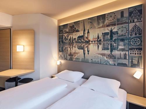 two beds in a room with a picture on the wall at B&B HOTEL Lippstadt in Lippstadt