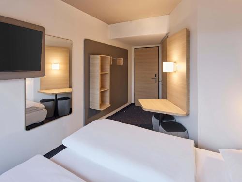 a hotel room with a bed and a tv at B&B HOTEL Lippstadt in Lippstadt