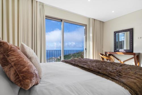 a bedroom with a large bed with a large window at Casa da boa vista in Canhas