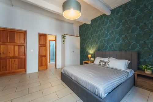a bedroom with a bed and a green wall at Suite 2 at Palazzo Seraphim Boutique living in St Julians in St. Julianʼs