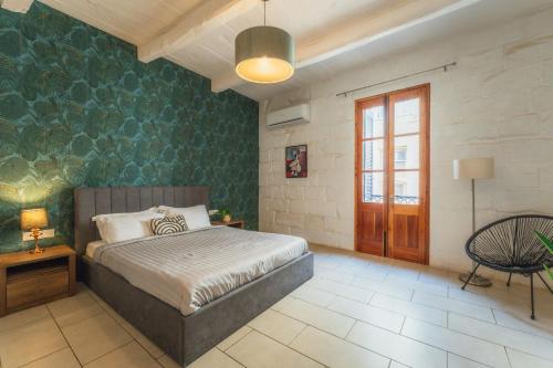 a bedroom with a bed and a green wall at Suite 2 at Palazzo Seraphim Boutique living in St Julians in St. Julianʼs
