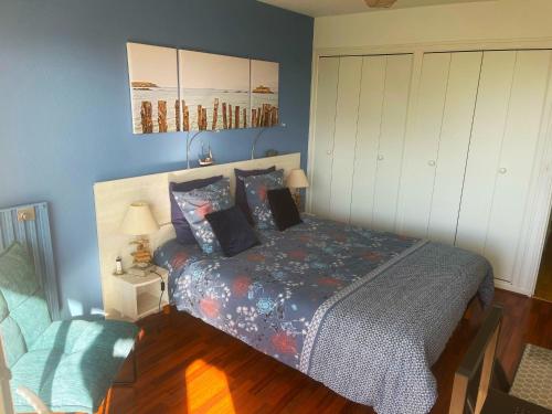 a bedroom with a bed and a chair at Le Balcon de la Conchée in Saint Malo