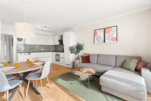 a living room and kitchen with a couch and a table at Zentral und Ruhig am Park - 2BR - gratis Parken - 2 Balkone in Graz