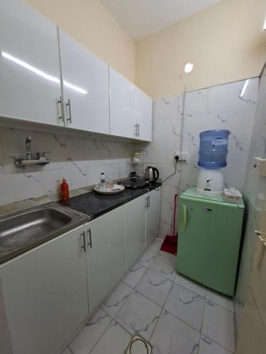 a small kitchen with a sink and a green refrigerator at Friendlyhomes in Al Ain