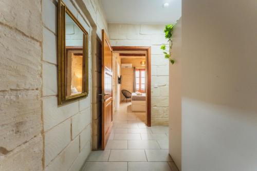 a hallway with a tile floor and a mirror at Suite 3 at Palazzo Seraphim Boutique living in St Julians in St. Julianʼs