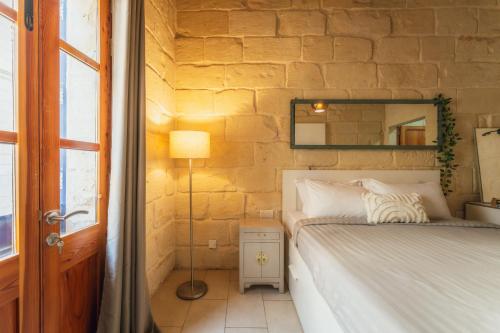 a bedroom with a bed and a mirror at Suite 3 at Palazzo Seraphim Boutique living in St Julians in St. Julianʼs