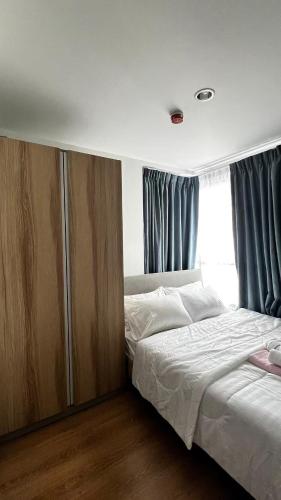 a bedroom with a bed and a large window at Centrio 2 bed rooms 52 in Ban Lo Long
