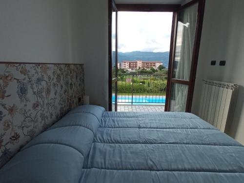 a bedroom with a bed with a view of a pool at Belmonte Holiday Apartment in Brezzo