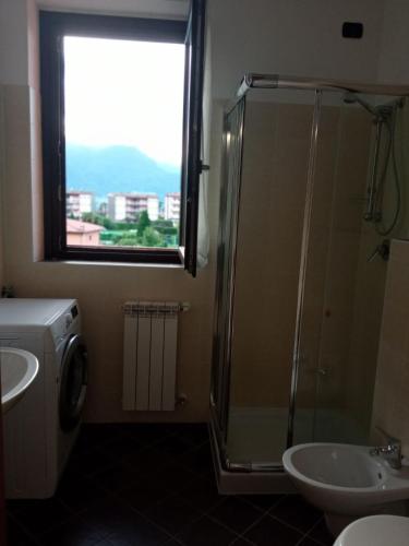 a bathroom with a shower and a sink and a window at Belmonte Holiday Apartment in Brezzo