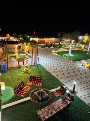 a view of a courtyard at night with a fire pit at Private farm Pool games Ras alkhaimah in Maghribīyah