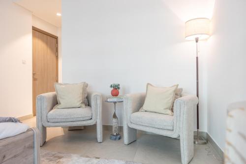 a living room with two chairs and a lamp at Bloomfields Dazzling 1BR in Saadiyat Island in Abu Dhabi