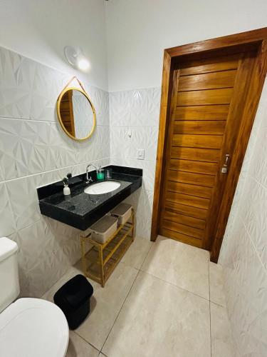 a bathroom with a black sink and a toilet at Loft 2 quartos with full kitchen in Uruçuca