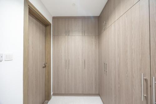 a closet with wooden cabinets in a room at Bloomfields Dazzling 1BR in Saadiyat Island in Abu Dhabi