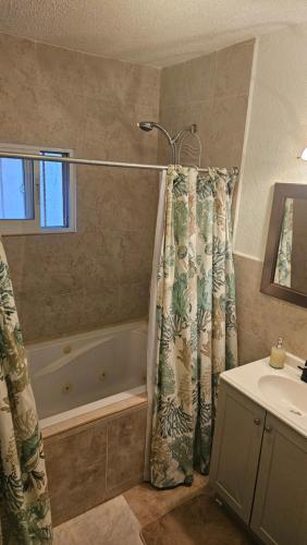 a bathroom with a shower curtain and a sink at Tranquility House Cancun in Cancún