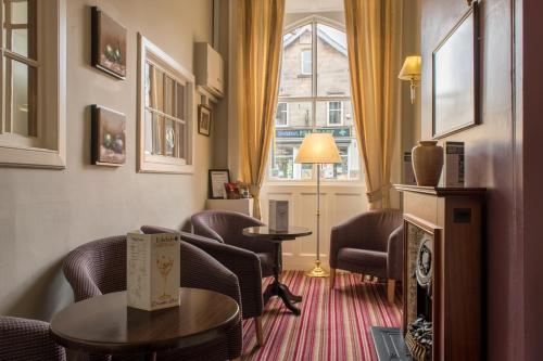 a living room with chairs and a table and a window at Eskdale Hotel in Langholm