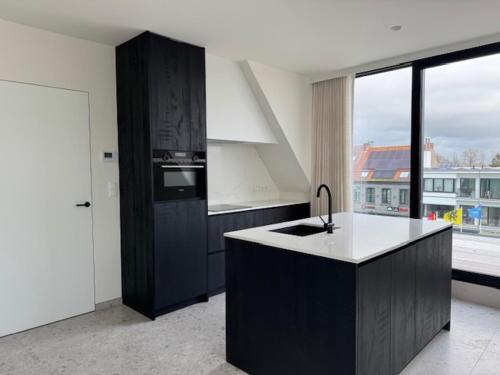 a kitchen with a black and white counter top at The Corner -FRANS in Beernem