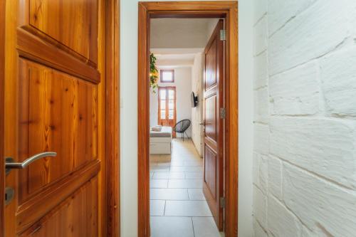 a hallway with a wooden door and a living room at Suite 4 at Palazzo Seraphim Boutique living in St Julians in St. Julianʼs
