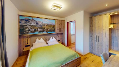 a bedroom with a bed with a painting on the wall at Smarthotel inAlpe in Obertauern