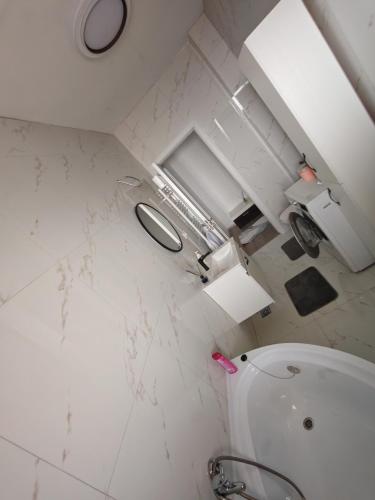 a white bathroom with a sink and a toilet at Apartament Dem Rădulescu, Rm Vâlcea in Troian