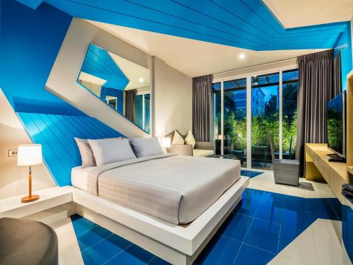 a bedroom with a white bed and blue walls at Atelier Suites in Bangkok