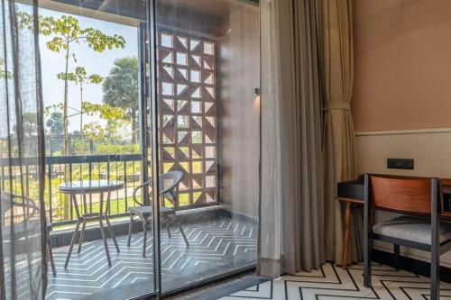 a room with a balcony with a table and chairs at Hotel Sonar Bangla Susunia in Kālipahāri