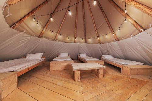 ein Zimmer mit Betten und Bänken in einer Jurte in der Unterkunft Moon Glamping in Benczyn