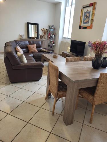 a living room with a table and a couch at entre arènes et maison carrée in Nîmes