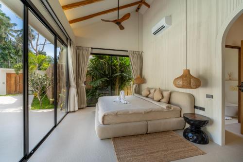 a bedroom with a bed and a couch in a room at K Villas Phangan 04 in Ban Madua Wan